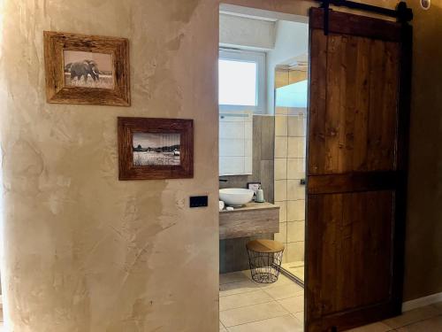 a bathroom with a wooden door and a sink at Villa Basilicata in Pedale