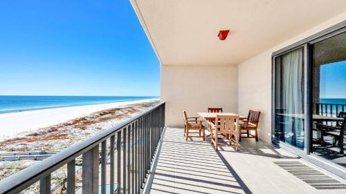 a balcony with a table and chairs and the beach at Phoenix X 514 condo in Orange Beach