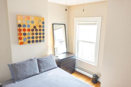 a bedroom with a bed and a mirror at Boston Landing Stays in Boston