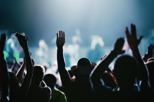 a crowd of people with their arms up at a concert at Nine Yards Bell Tents - Lytham in Lytham St Annes