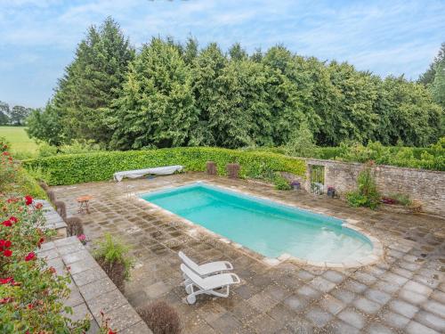 a swimming pool with two lawn chairs and a bench at The Mill Lodge in Malmesbury