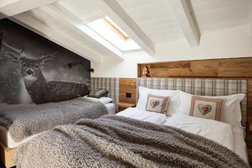 a bedroom with a bed and a deer on the wall at Casa Orso Elio - Si Mezzana Home in Mezzana