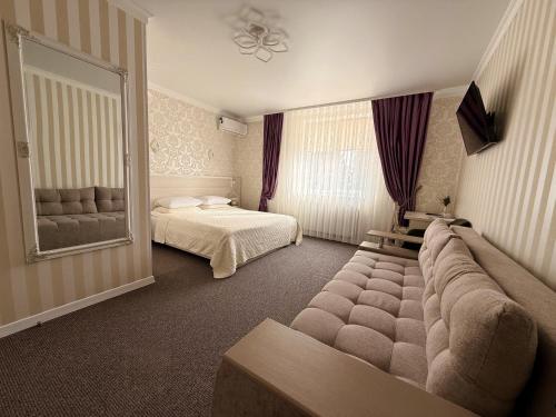 a bedroom with a couch and a bed and a mirror at Готель Лаванда in Khmelnytskyi