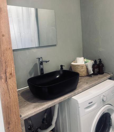 a black sink sitting on a counter next to a washing machine at Nára house 3 in Spata