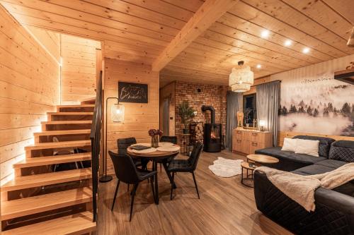 a living room with a staircase and a couch and a table at Zacisze Anioła in Łobozew