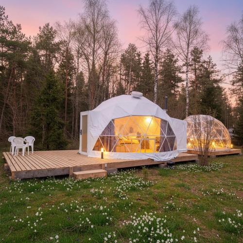 a large tent in a field with a wooden deck at Bubble House glamping tent Odulemma in Odulemma