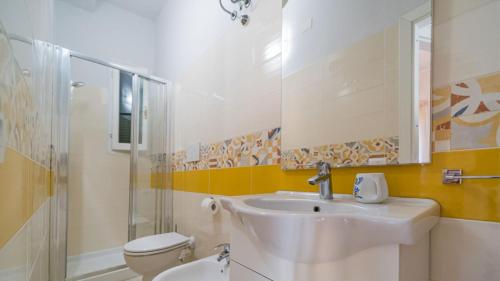 a bathroom with a sink and a toilet and a mirror at Suite Alarcon - Goelba in Porto Azzurro