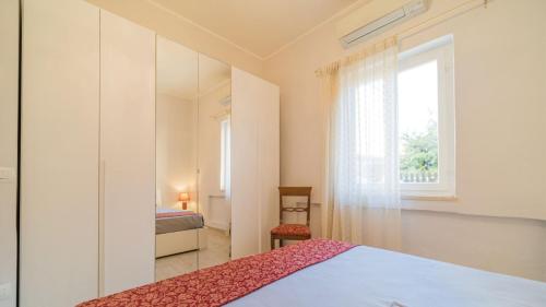 a bedroom with a bed and a window at Suite Alarcon - Goelba in Porto Azzurro