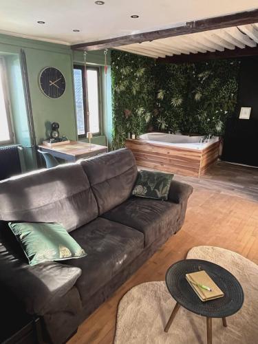 a living room with a leather couch and a tub at Romantic love room house in Aix