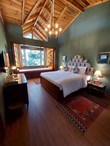 a bedroom with a large bed and a large window at Abbotsford Prasada Bhawan in Nainital