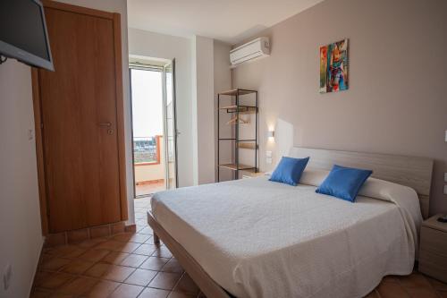a bedroom with a large bed with blue pillows at Ravè in Praia a Mare