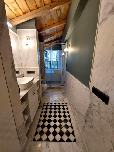 a bathroom with a sink and a checkered floor at Abbotsford Prasada Bhawan in Nainital