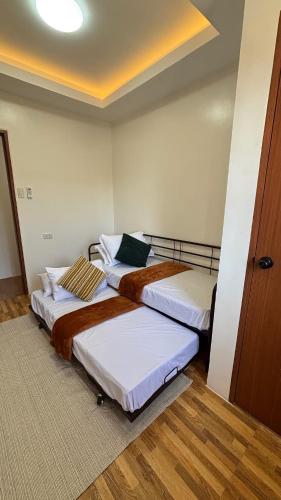 two beds sitting in a room with a door at R&G Residences in Legazpi