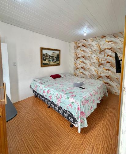 a bedroom with a bed and a stone wall at Apartamento no Centro in Manaus