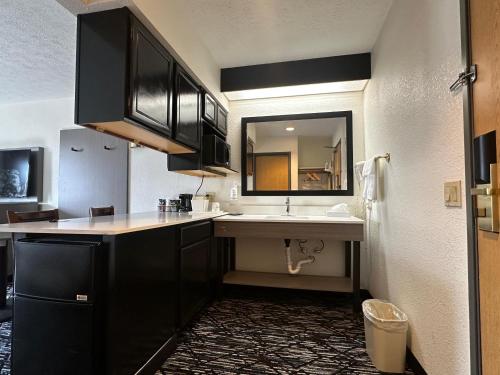a bathroom with a sink and a large mirror at Ramada by Wyndham Strasburg Dover in Strasburg