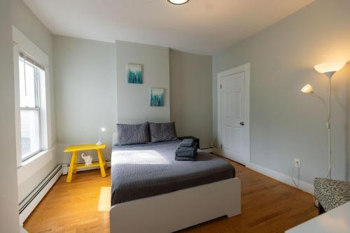 a bedroom with a bed and a yellow table at Boston Landing Stays in Boston