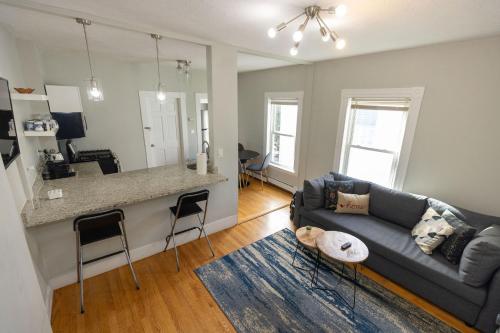 a living room with a blue couch and a kitchen at Boston Landing Stays in Boston