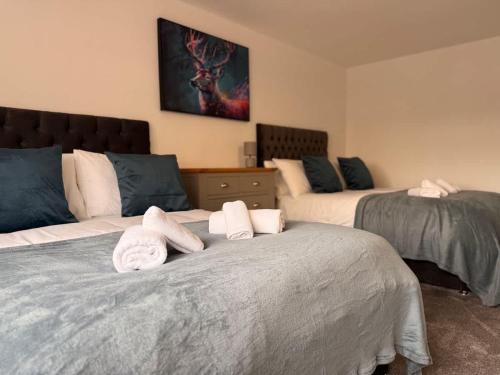 a bedroom with two beds with towels on them at Low Street Escape 3 Bed, Sleeps 9, Gated Drive, WiFi, Contractors in Great Wyrley
