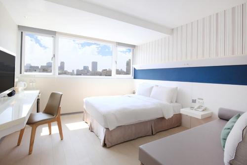a hotel room with a bed and a desk and a couch at Dandy Hotel - Tianmu Branch in Taipei