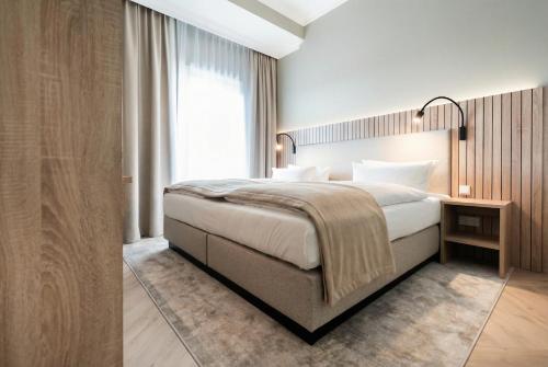 a bedroom with a large bed and a large window at Yachthafen Barth - Ferienwohnung und Penthouses in Barth