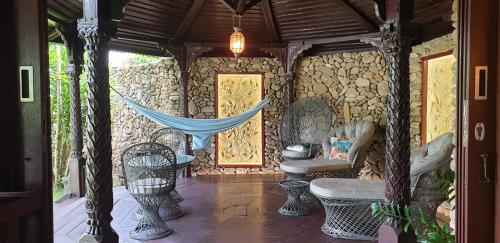 a porch of a house with a hammock on it at Robinson's Cove Villas in Papetoai