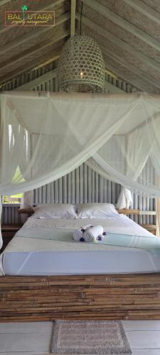 a bed in a room with a canopy at Rumah Putih Beachfront Bungalow in Tegallengah