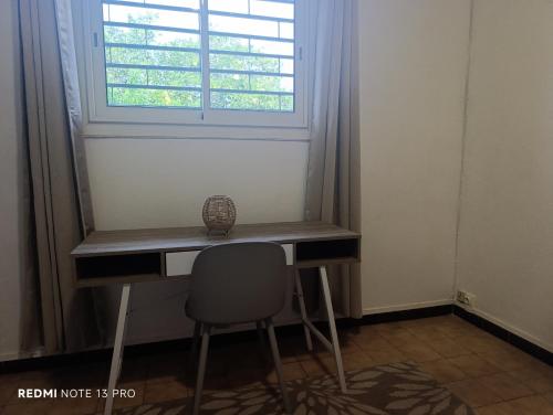 a desk with a chair in front of a window at NM-Housing in Saint-Denis