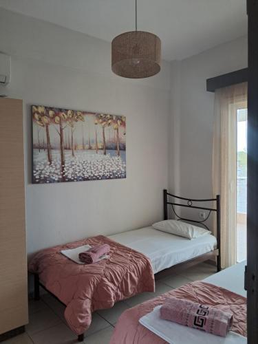 a bedroom with two beds and a painting on the wall at Villa Marili in Paralia Katerinis