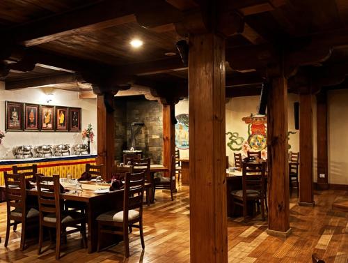 a dining room with tables and chairs and a bar at Yangkhil Resort in Tongsa