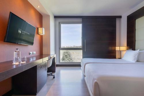 una camera d'albergo con un grande letto e una televisione di Eurostars i-hotel Madrid a Pozuelo de Alarcón