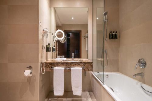 un bagno con vasca, lavandino e specchio di Eurostars i-hotel Madrid a Pozuelo de Alarcón