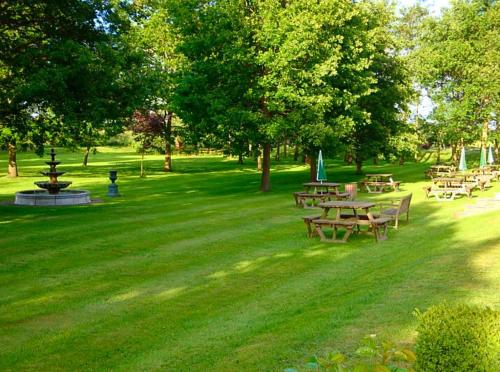 a group of tables and benches in a park at The Boars Head Hotel in Sudbury