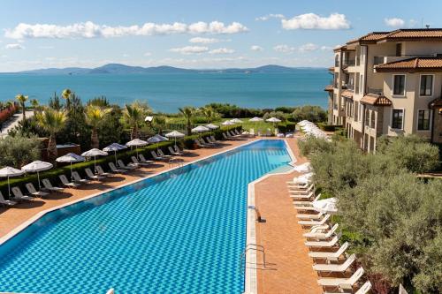 an overhead view of a swimming pool with chairs and umbrellas at Burgas Beach Resort Apartments in Burgas