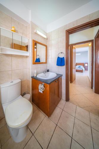 a bathroom with a toilet and a sink at Infinity Blue Villa w Pool in Pomos