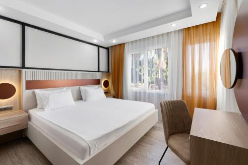 a bedroom with a bed and a desk and a chair at River Park Residence Lara in Antalya