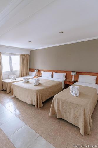 a hotel room with two beds with towels on them at Ortegal Urban Suites in Mar del Plata