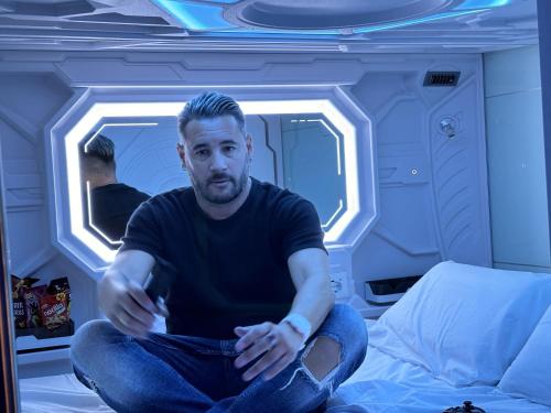 a man sitting on a bed in a room at Futurotel Space Spa Madrid Center in Madrid