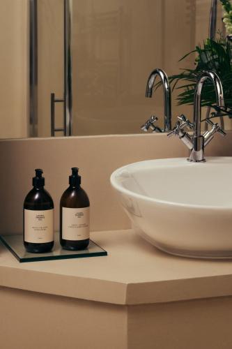 eine Badezimmerablage mit Waschbecken und Spiegel in der Unterkunft Lyla Rooms in Edinburgh