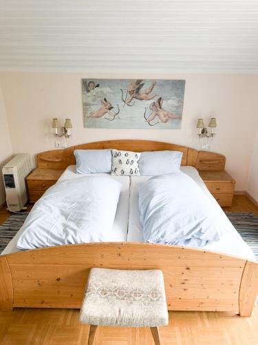a bedroom with a wooden bed with white sheets at Rosis Cottage in Lienz