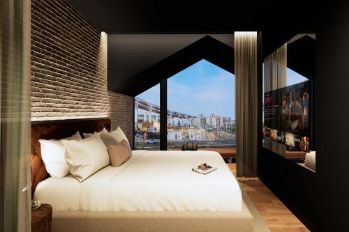 ein Schlafzimmer mit einem weißen Bett und einem großen Fenster in der Unterkunft Docas Hotel Lisbon in Lissabon