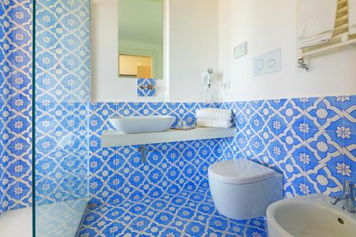 a blue and white bathroom with a sink and a toilet at Domo20 Hotel & Rooftop in Vico Equense