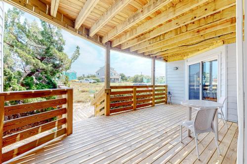 a wooden deck with a table and chairs on it at Flip Flops Inn in Duck