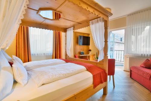 a bedroom with a canopy bed and a red couch at Altkölnischer Hof in Bacharach