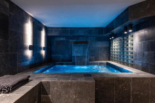 a jacuzzi tub in a bathroom with a blue ceiling at The Saints Inn & Spa in Athens