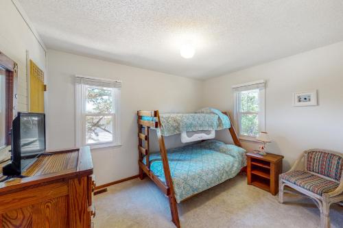 a bedroom with a bunk bed and a tv at Pelican Perch in Duck