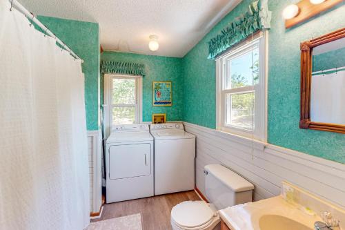 a washer and dryer in a bathroom with green walls at Pelican Perch in Duck
