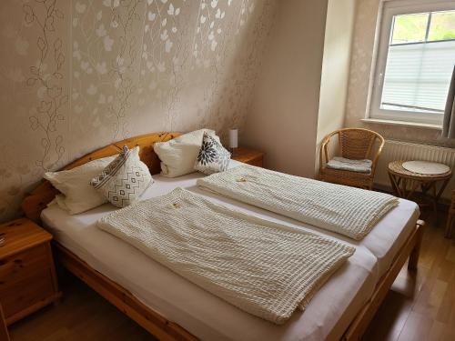 a bedroom with a bed with white sheets and pillows at Weingut Matthias Dauns in Reil