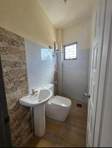 a bathroom with a sink and a toilet and a window at Rweydz Guest Inn Dorm in Tagbilaran City