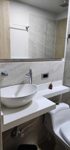 a bathroom with a white sink and a toilet at Hotel Distrito Unicentro in Medellín