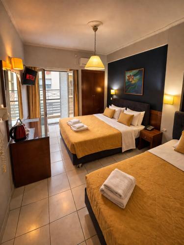 a hotel room with two beds with towels on them at Epidavros Hotel in Athens